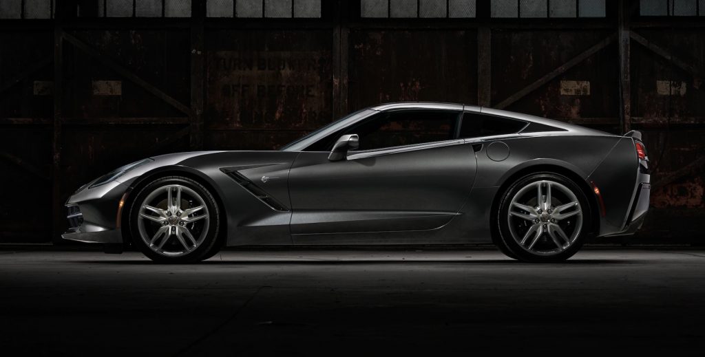 Corvette Stingray in profile against an industrial wall