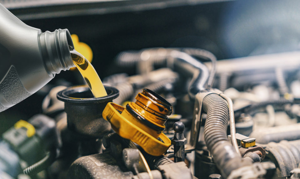 Pouring oil into car engine.