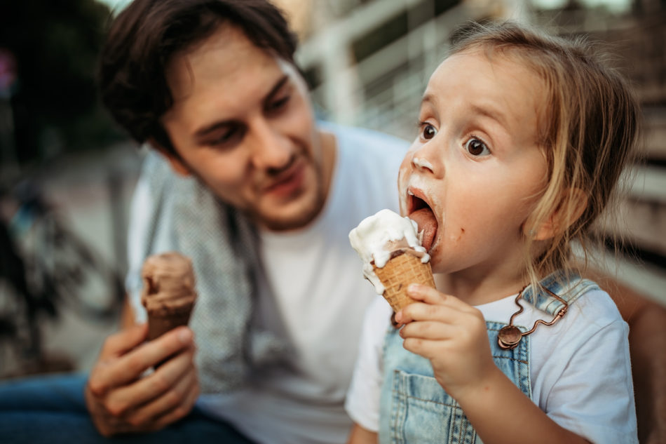 Little girl and her dad enjoying an ice cream cone