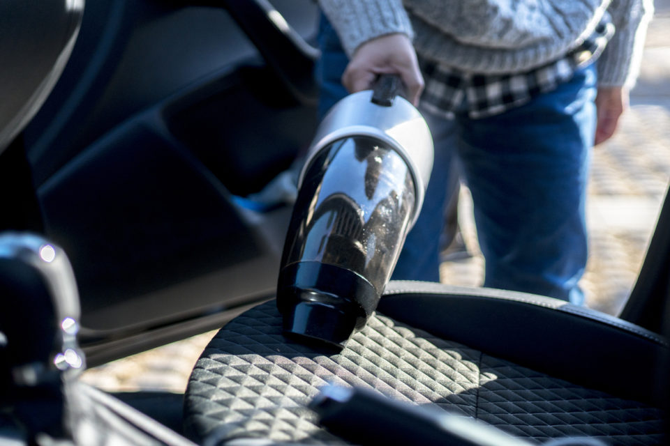 cleaning car interior with portable vacuum cleaner