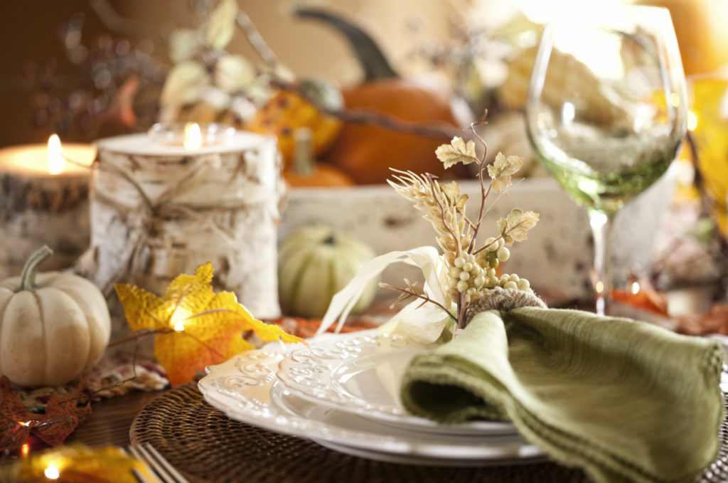 Dining table with beautiful traditional centerpiece filled with pumpkins and gourds.