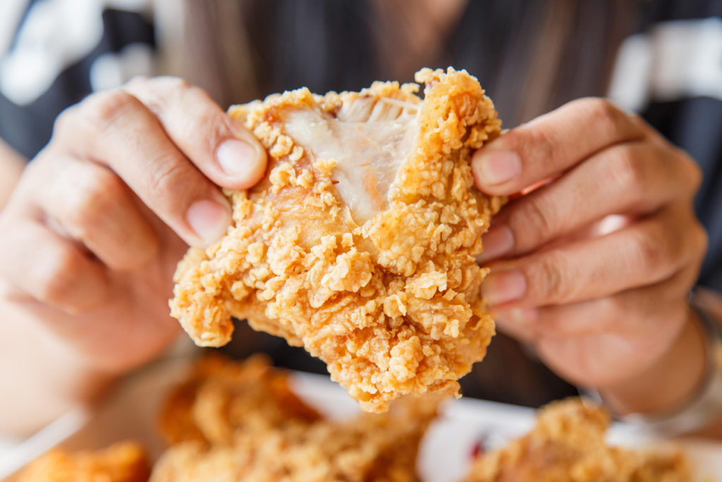 Hand holding fried chicken