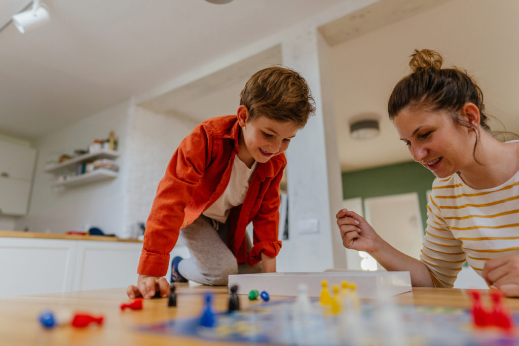 Mother and son playing board game at home