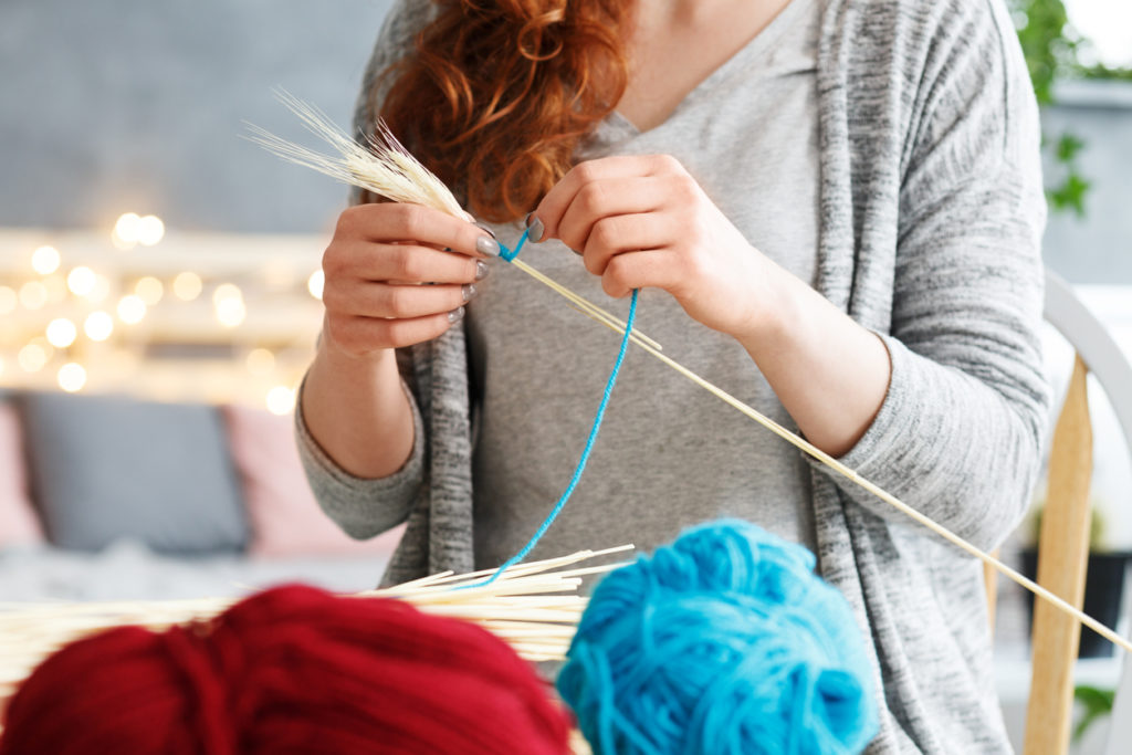 Young woman making colorful creative yarn decorations