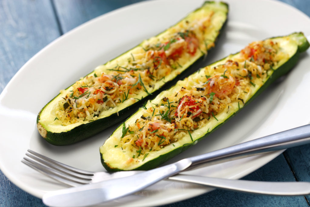 baked zucchini boats on a white plate