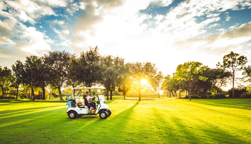 family driving golf cart on course