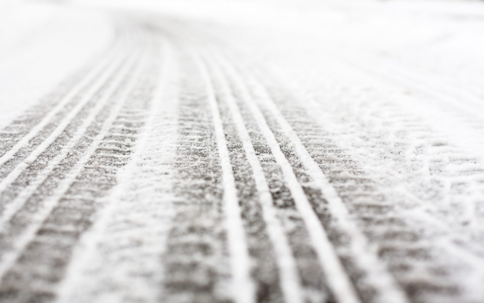 Wheel tracks on the winter road covered with snow.